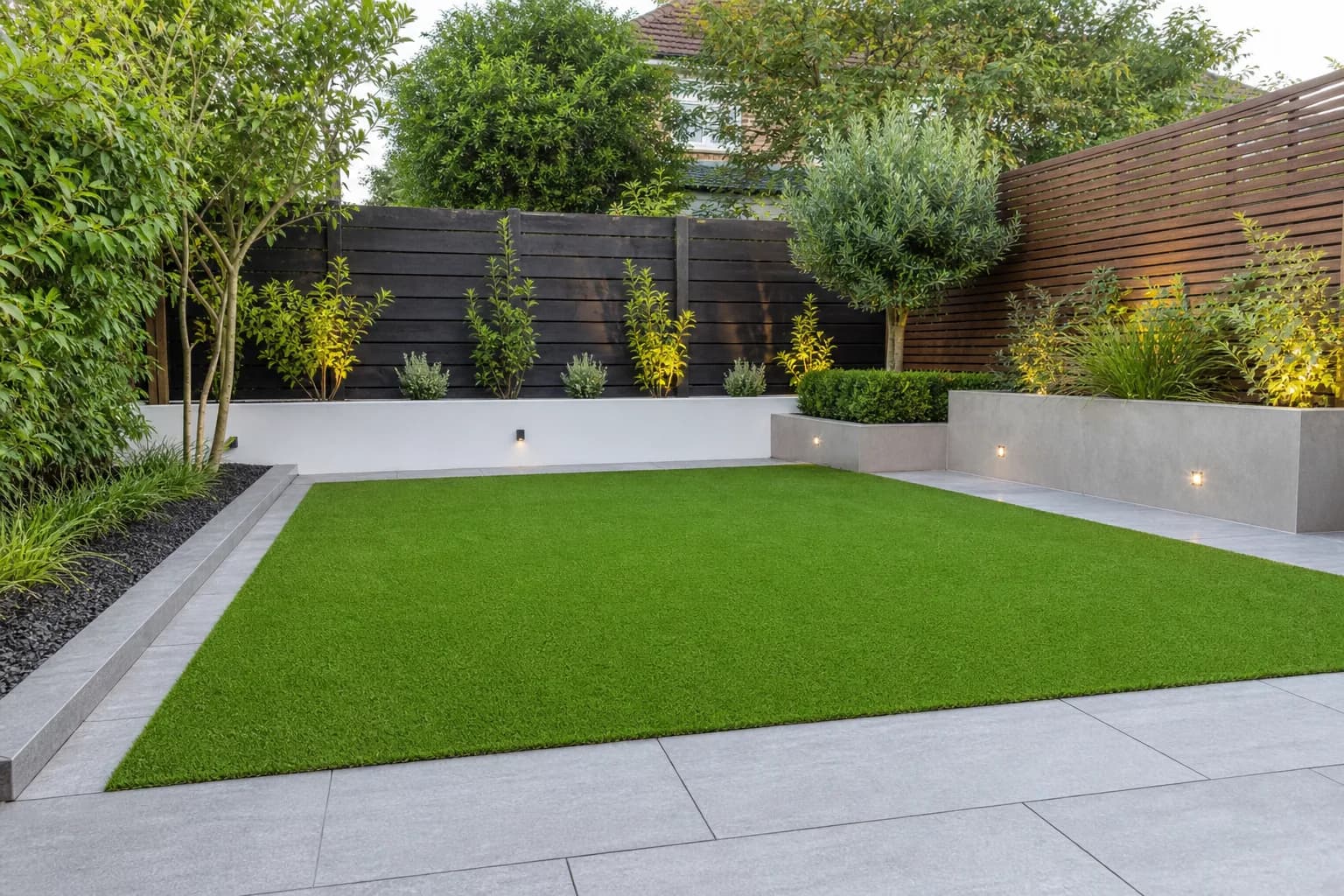 Neat low-maintenance artificial grass lawn with a paved border